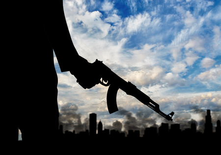 Terrorist concept. Silhouette terrorists, against the background of the urban landscape in smokeの写真素材
