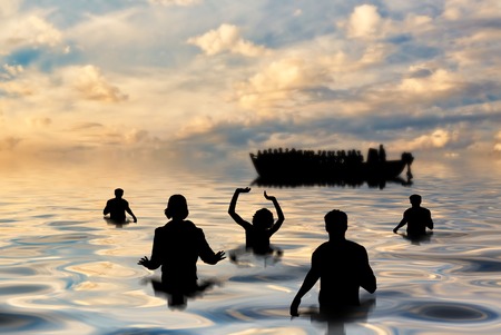 Refugees concept. Refugees swim to shore against the backdrop of boatsの写真素材