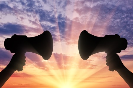 Megaphone. The loudspeaker in his hand on a sunset backgroundの写真素材