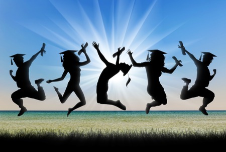 Graduates near the sea jumping for joy. concept of educationの写真素材