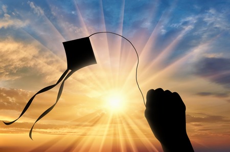 Hand holding kite on sunset. Concept freedomの写真素材