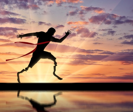 Disabled paralympians with two prosthetic crossing finish tape and reflection. Concept sport and willpowerの写真素材