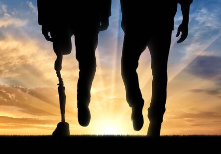 Leg man with prosthesis and normal legs on background sunset. Concept disabled personの写真素材