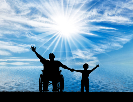 Happy disabled person in wheelchair hold son for hand and they happy near sea day. Concept happy disabled and familyの写真素材