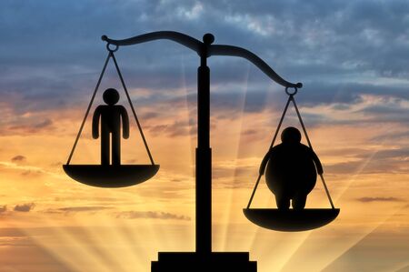 Icon fat man outweighed normal on scales on background sunset. Concept obesityの写真素材