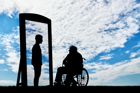 disabled man in a wheelchair and his reflection in mirror of a healthy man against the sky. disabled rehabilitation conceptの写真素材
