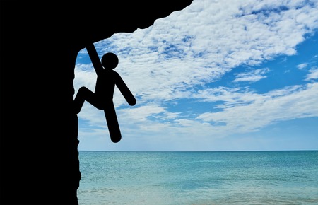 Achieving the concept of purpose. Human Icon climber rises on rockの写真素材