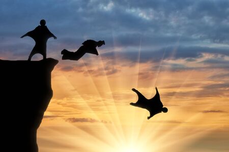 Wingsuit extreme sports. Men in suits for a wingsuit jump from a hill on a sunset backgroundの写真素材