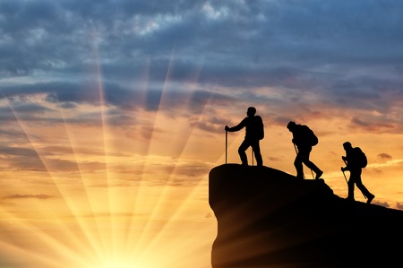 Silhouette climbers ascending to top of mountain. Concept teamworkの写真素材