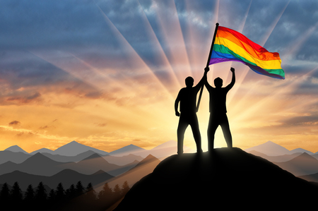 Silhouette of a gay couple with rainbow flag at the topの写真素材