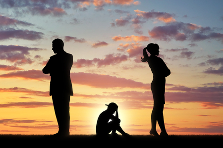 Conflict and divorce in the family. Sad child in desperation between choice of parentsの写真素材