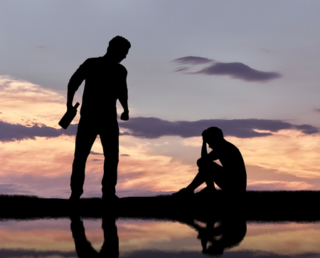 Child abuse and bullying. Silhouette of a crying boy and an aggressive drunken fatherの写真素材