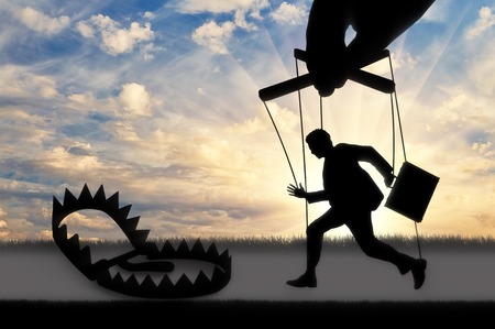 Hand manage and man marionette runs into trap. Concept of a marionetteの写真素材