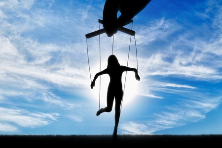 Hand controls the woman's marionette. Manipulation conceptの写真素材