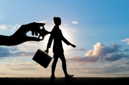 Hand gets a key windup toy business woman. Concept of businessの写真素材