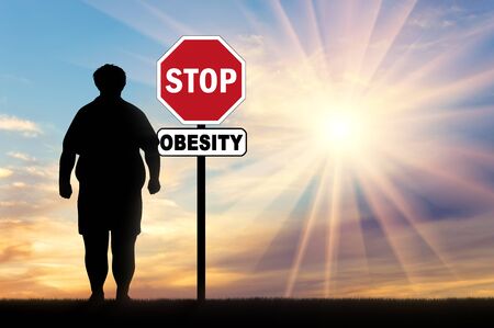 Fat man and a sign of stop obesity. Concept of obesityの写真素材
