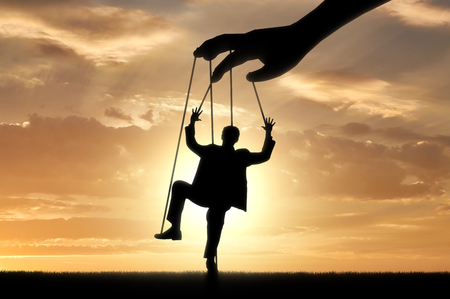 Hand controls man marionette. Manipulation conceptの写真素材