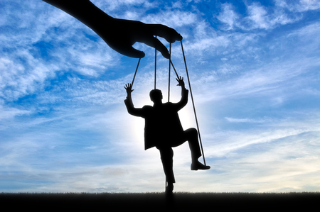 Hand controls man marionette. Manipulation conceptの写真素材