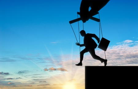 Hand rules, and man-marionette runs into abyss. Concept of a marionetteの写真素材