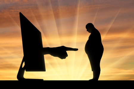 Cyberbullying. A hand from the computer shows a finger on a fat manの写真素材
