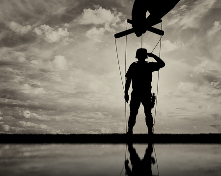 Hand rules, and soldier-marionette salutes. Concept of a marionetteの写真素材
