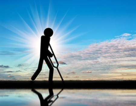 Disabled person with crutches in hands of a person icon. Concept of disabled peopleの写真素材