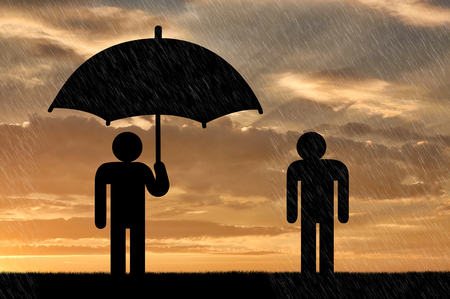 Concept of selfishness and greed. Man under an umbrella and a man in rainの写真素材
