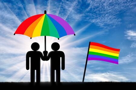 Two gay men under a rainbow umbrella near a rainbow flag against the skyの写真素材