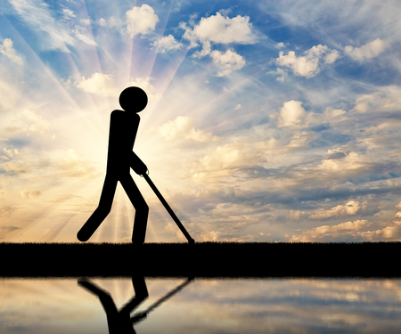 Blind invalid walks with a cane in his hands. Concept of disabilityの写真素材