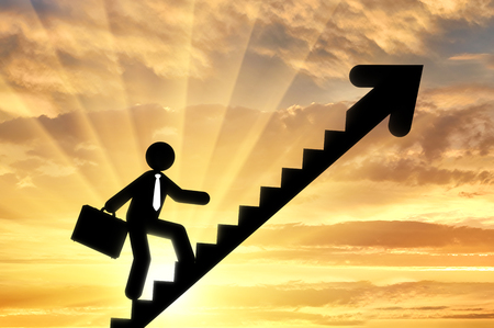 Concept of business purpose. Businessman with briefcase walking up stairs of the arrowの写真素材