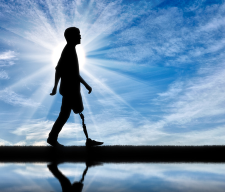 Walking disabled with a prosthetic leg against the sky and the river with its reflectionの写真素材