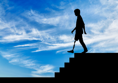 Disabled person with a prosthetic leg descends down the stairsの写真素材