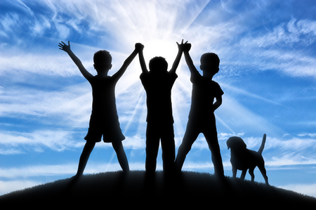 Childhood concept. Silhouette of three happy children and dogsの写真素材