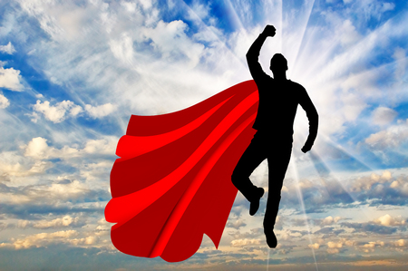 Superman businessman superhero. Silhouette of a businessman in the image of a superman flying in the skyの写真素材
