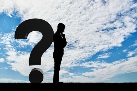 The concept of solving problems in business. Silhouette businessman thinking next to the question markの写真素材