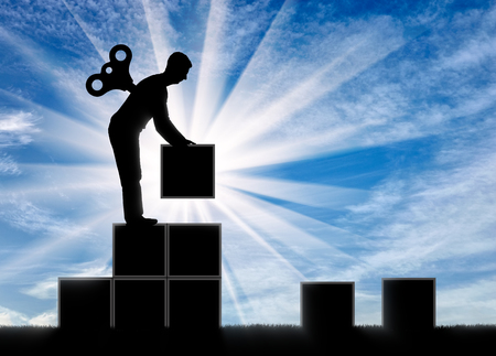 The concept of career growth and motivation. Silhouette of a worker with a clockwork mechanism in the back for a staircase of blocksの写真素材