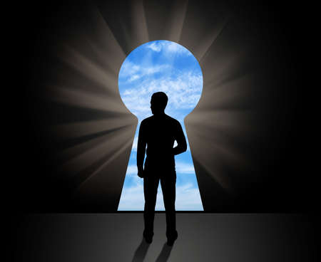 The concept of new business opportunities. Silhouette of businessman standing in front of open doorsの写真素材