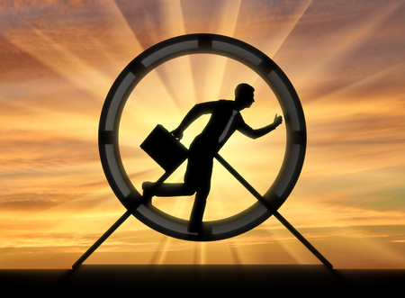 The notion of running like a hamster in a wheel. Silhouette running and hardworking businessman in a hamster wheelの写真素材