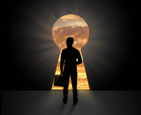 The concept of business vision for the future . Silhouette of businessman standing in front of the doors keyholeの写真素材