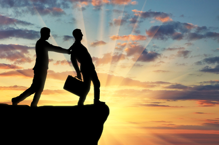 Silhouette of a businessman pushes another businessman to the abyss. The concept of a rival in businessの写真素材