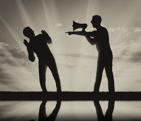 Silhouette of an evil boss with a loudspeaker in his hand, screaming at a subordinateの写真素材