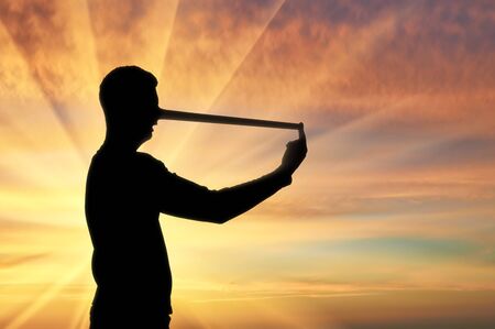 Silhouette of a businessman with a long nose that lies. The concept lies and deceit