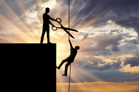 A businessman with big scissors in his hands intends to cut the rope along which the competitor creeps up. Concept of business rivalryの写真素材