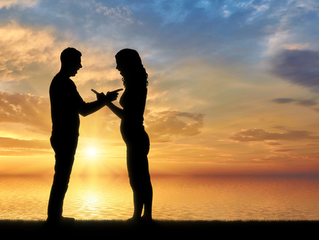 Silhouette man and woman yelling at each other. The concept of strife and conflictの写真素材