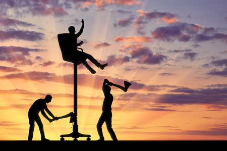 Business competitors are cutting an ax with a chair on which a businessman sits high. The concept of envy of rivals to the success of another personの写真素材