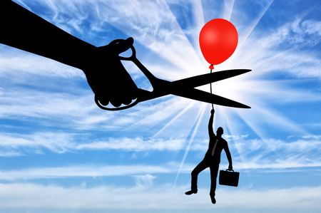 A man climbs up holding onto a balloon, and a hand with scissors intends to cut it off. The concept of riskの写真素材