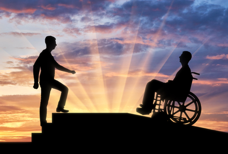 A disabled person in a wheelchair climbs up the ramp, and healthy man on the stairs. The concept of caring for the disabled in moving around the cityの写真素材