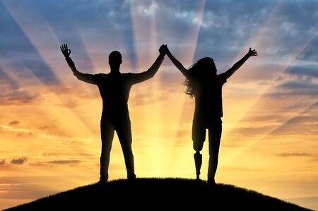 Happy man and woman holding hands with prosthetic arms and legs. The concept of disability and prostheticsの写真素材