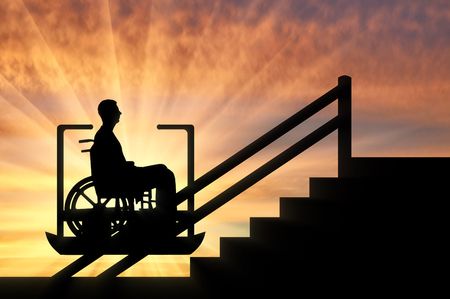 Disabled person climbs on elevator for disabled on stairs. Concept disabled lift, elevator, handicapの写真素材