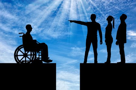 Crowd of people makes it clear to the disabled person in the wheelchair that he must walk away and the gap between them. The concept of Discrimination of people with disabilities in societyの写真素材